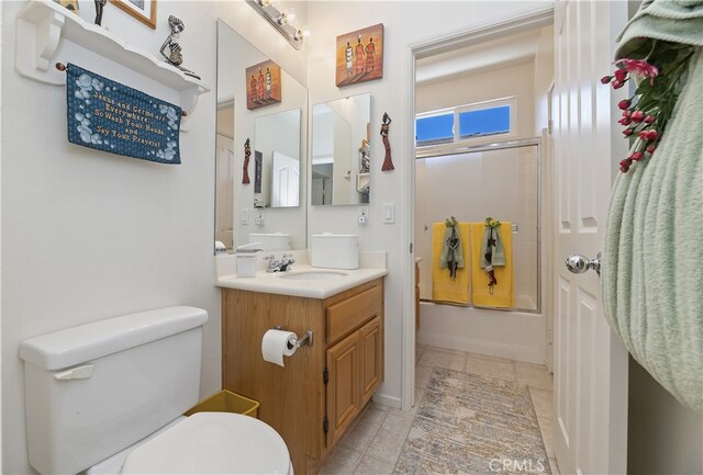 full bath with vanity, toilet, tile patterned flooring, and combined bath / shower with glass door