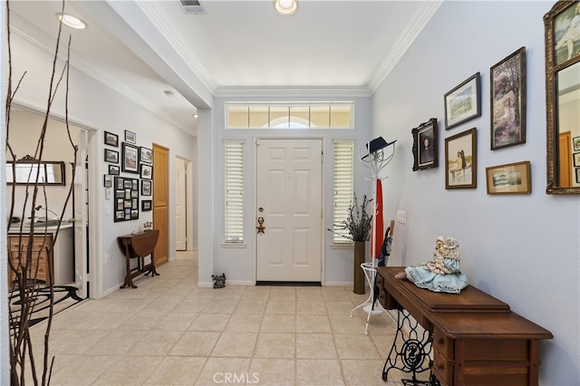 foyer entrance with visible vents, crown molding, and baseboards
