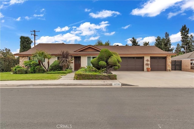 ranch-style house with driveway, stucco siding, and an attached garage