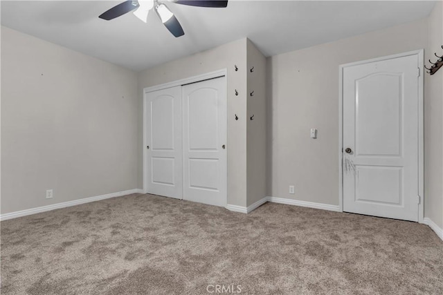 unfurnished bedroom featuring a closet, carpet flooring, a ceiling fan, and baseboards