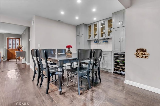 dining room featuring wine cooler, recessed lighting, dark wood finished floors, and baseboards