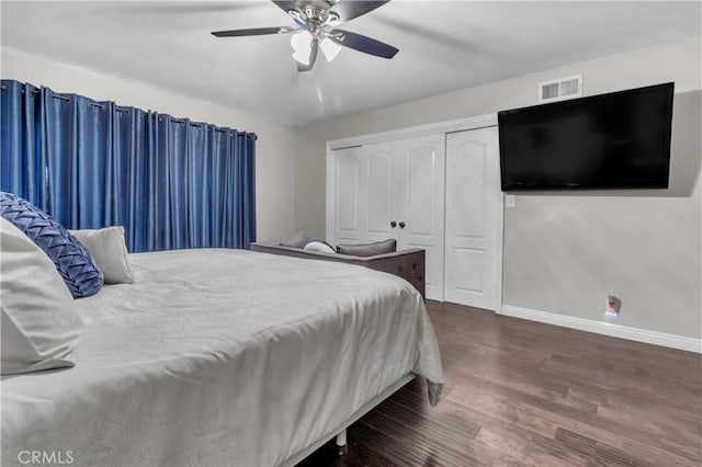 bedroom with a closet, a ceiling fan, visible vents, baseboards, and wood finished floors