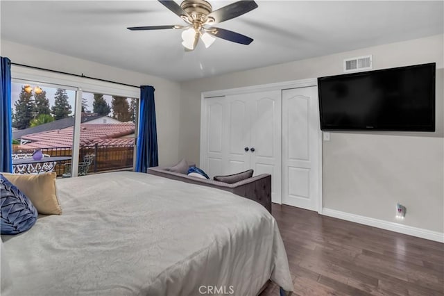 bedroom with a closet, ceiling fan, visible vents, baseboards, and wood finished floors