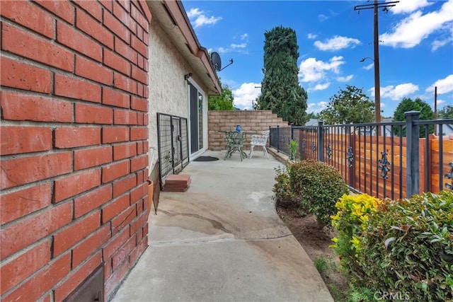 view of side of home with fence and a patio area