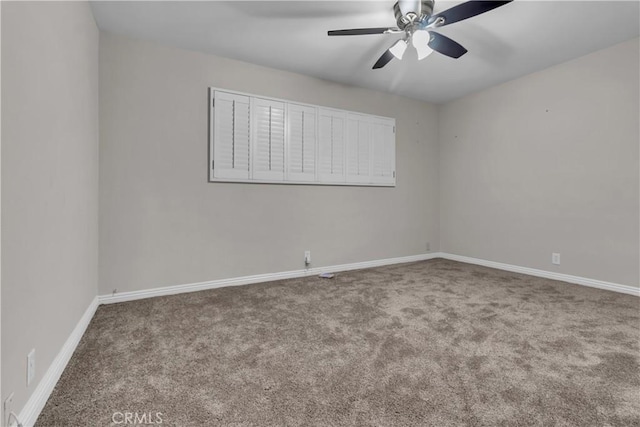empty room with ceiling fan, carpet, and baseboards