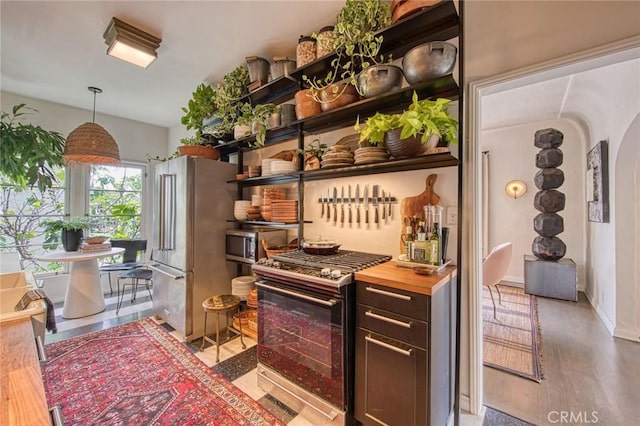 4912 Edgewood Pl, Los Angeles, CA 90019 - bar featuring appliances with stainless steel finishes, hanging light fixtures, arched walkways, baseboards, and wood finished floors