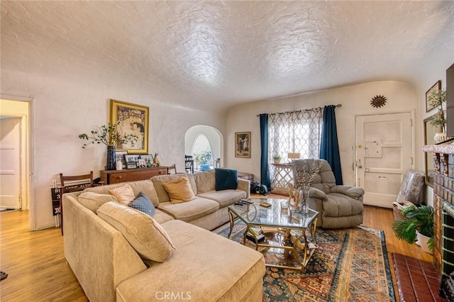 4912 Edgewood Pl, Los Angeles, CA 90019 - living room featuring light wood-style floors, arched walkways, and a textured ceiling