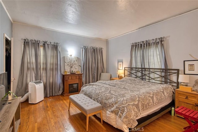 4912 Edgewood Pl, Los Angeles, CA 90019 - bedroom featuring crown molding, a glass covered fireplace, wood finished floors, and multiple windows