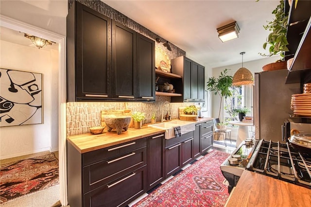 4912 Edgewood Pl, Los Angeles, CA 90019 - kitchen with open shelves, a sink, decorative light fixtures, decorative backsplash, and butcher block counters