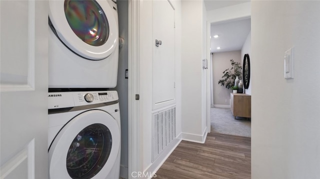 washroom featuring laundry area, wood finished floors, visible vents, baseboards, and stacked washer and dryer