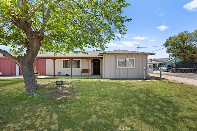 ranch-style house featuring board and batten siding, a front lawn, and fence