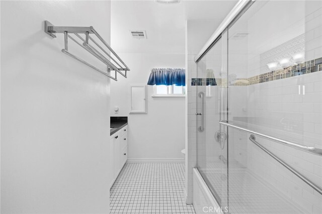 bathroom featuring vanity, toilet, tile patterned flooring, visible vents, and tiled shower