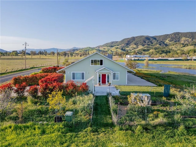 view of front of house featuring a mountain view and a front yard
