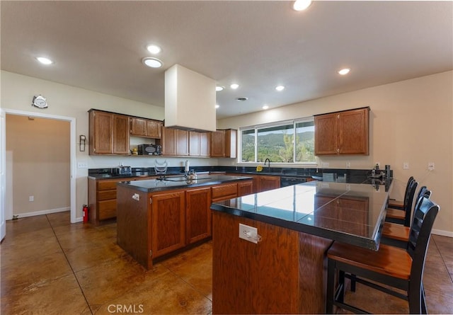 kitchen with brown cabinets, open shelves, dark tile patterned floors, a peninsula, and a breakfast bar area