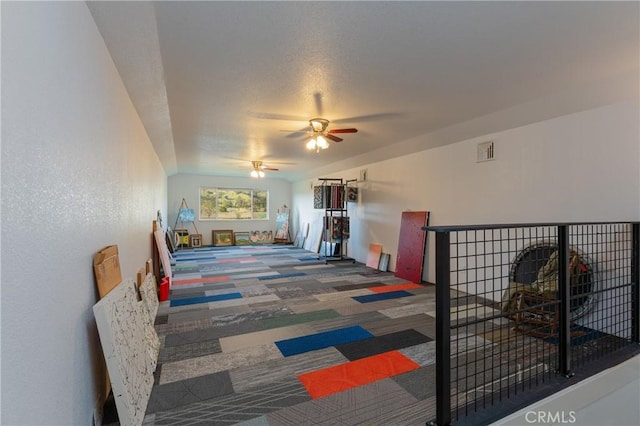 interior space featuring a ceiling fan, visible vents, and carpet