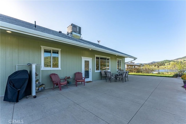 rear view of house featuring a patio area, outdoor dining space, and a mountain view