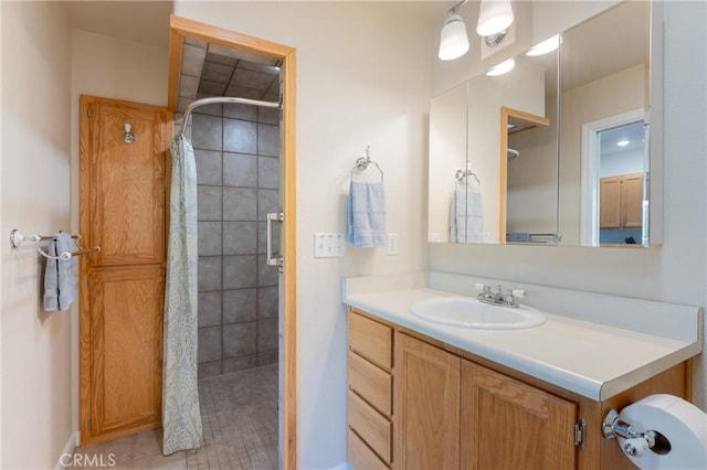 full bathroom featuring a tile shower and vanity
