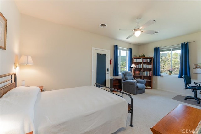 bedroom with carpet, visible vents, baseboards, and multiple windows