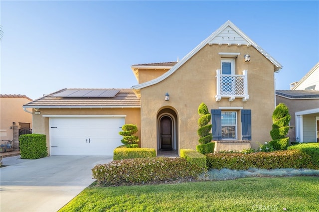 traditional-style house featuring stucco siding, roof mounted solar panels, concrete driveway, and a garage