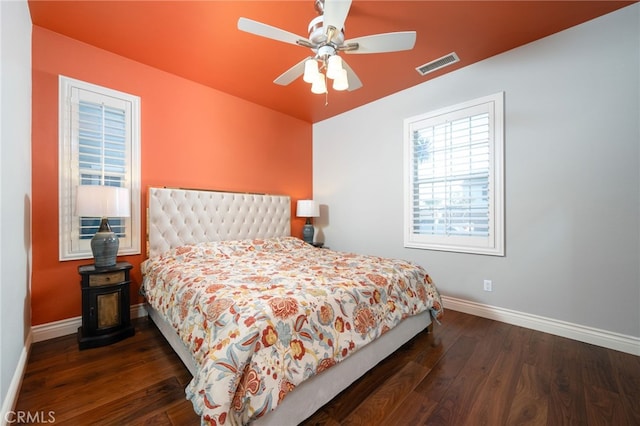 bedroom featuring visible vents, hardwood / wood-style flooring, baseboards, and a ceiling fan