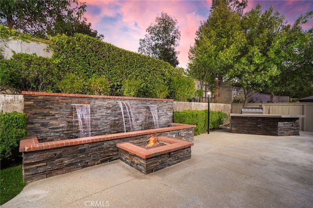 view of patio with fence, an outdoor fire pit, and area for grilling