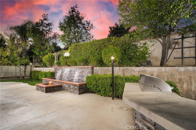 view of patio with area for grilling and fence