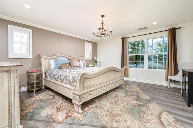 bedroom featuring wood finished floors, visible vents, crown molding, baseboards, and a chandelier