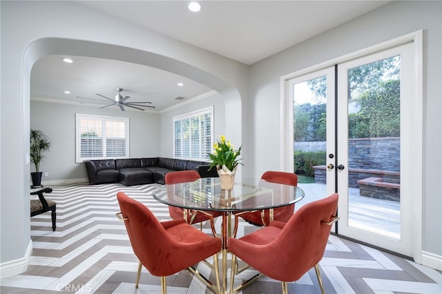 dining room featuring recessed lighting, arched walkways, and baseboards