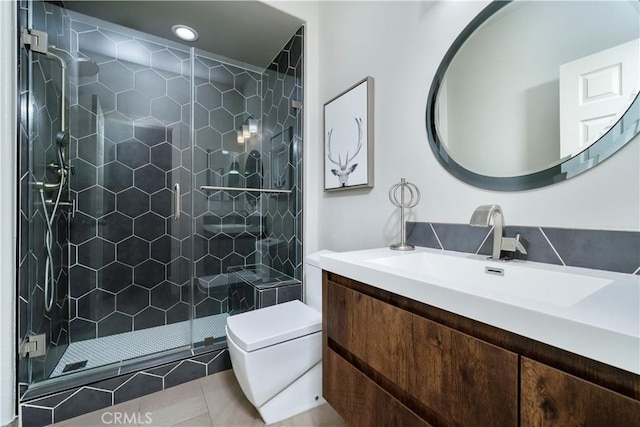 bathroom featuring vanity, toilet, a stall shower, and tile patterned floors