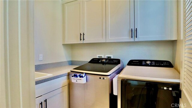 washroom with washing machine and clothes dryer and cabinet space