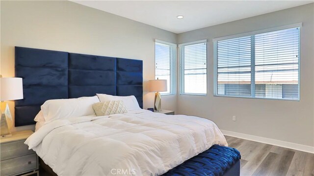 bedroom with wood finished floors, baseboards, and recessed lighting