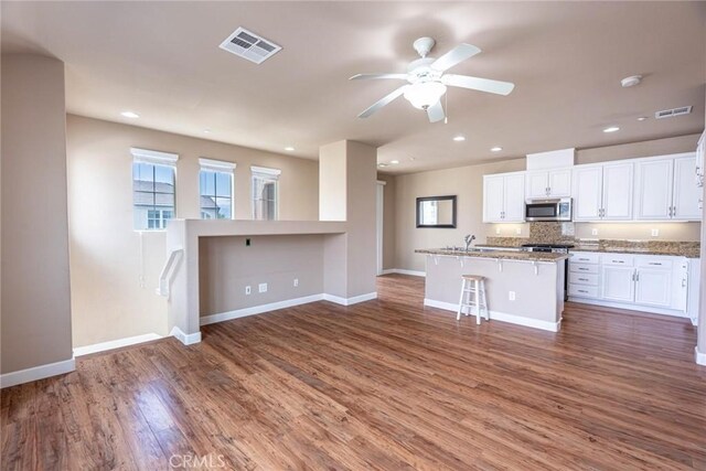 25102 Goodrich Ct, Stevenson Ranch, CA 91381 - unfurnished living room featuring wood finished floors, visible vents, baseboards, and ceiling fan