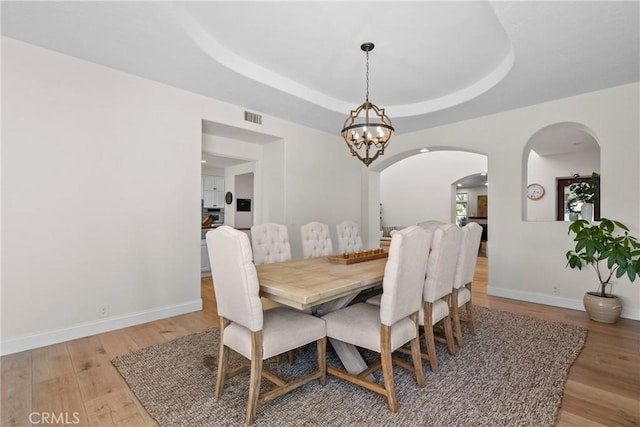 25174 Mulholland Hwy, Calabasas, CA 91302 - dining space featuring arched walkways, a chandelier, light wood-style flooring, and baseboards