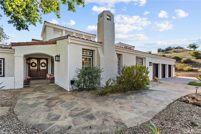 25174 Mulholland Hwy, Calabasas, CA 91302 - view of front of property featuring a tile roof, concrete driveway, stucco siding, and a chimney