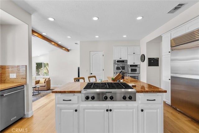 25174 Mulholland Hwy, Calabasas, CA 91302 - kitchen featuring stainless steel appliances, light wood-type flooring, recessed lighting, white cabinetry, and a kitchen island