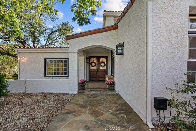 25174 Mulholland Hwy, Calabasas, CA 91302 - property entrance with stucco siding and a tiled roof