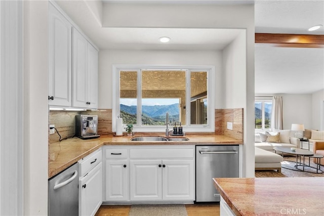 25174 Mulholland Hwy, Calabasas, CA 91302 - kitchen featuring stainless steel dishwasher, a sink, tasteful backsplash, white cabinetry, and recessed lighting