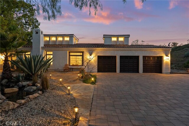 25174 Mulholland Hwy, Calabasas, CA 91302 - view of front of house with a garage, a tiled roof, decorative driveway, and stucco siding