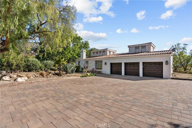 25174 Mulholland Hwy, Calabasas, CA 91302 - mediterranean / spanish house with a garage, decorative driveway, a tile roof, and stucco siding