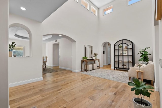 25174 Mulholland Hwy, Calabasas, CA 91302 - foyer entrance featuring light wood-style flooring, arched walkways, healthy amount of natural light, baseboards, and a high ceiling