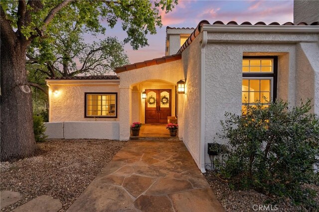 25174 Mulholland Hwy, Calabasas, CA 91302 - exterior entry at dusk with stucco siding and a tiled roof