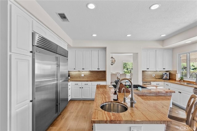25174 Mulholland Hwy, Calabasas, CA 91302 - kitchen featuring built in fridge, a sink, white cabinetry, recessed lighting, and a textured ceiling