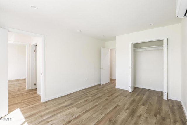 8751 Odessa Ave, North Hills, CA 91343 - unfurnished bedroom with an AC wall unit, light wood-style floors, and a closet