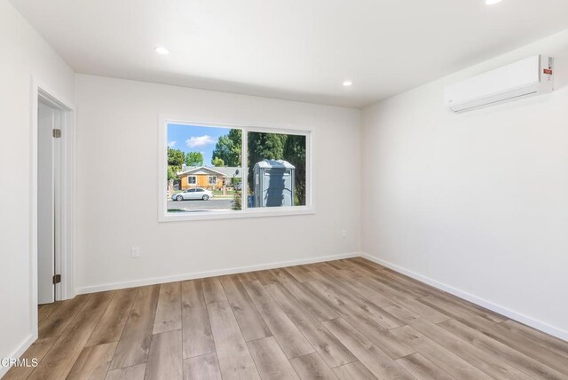 8751 Odessa Ave, North Hills, CA 91343 - unfurnished room with a wall mounted AC, light wood-style flooring, and recessed lighting