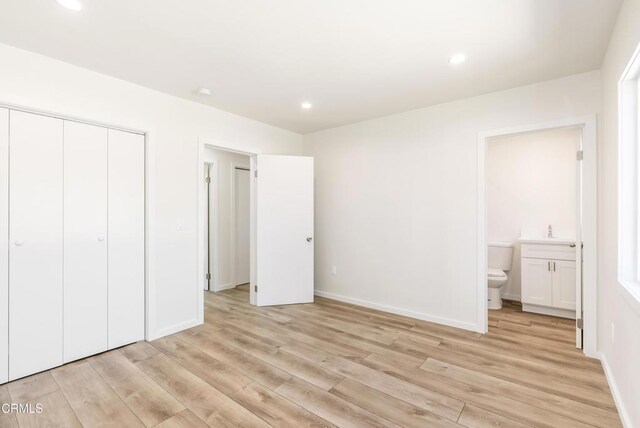 8751 Odessa Ave, North Hills, CA 91343 - unfurnished bedroom featuring light wood-style flooring, a closet, connected bathroom, and recessed lighting