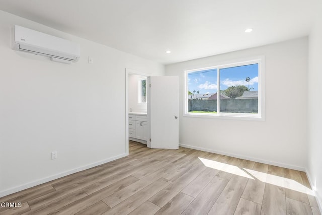8751 Odessa Ave, North Hills, CA 91343 - unfurnished bedroom with a wall unit AC, light wood finished floors, recessed lighting, and connected bathroom