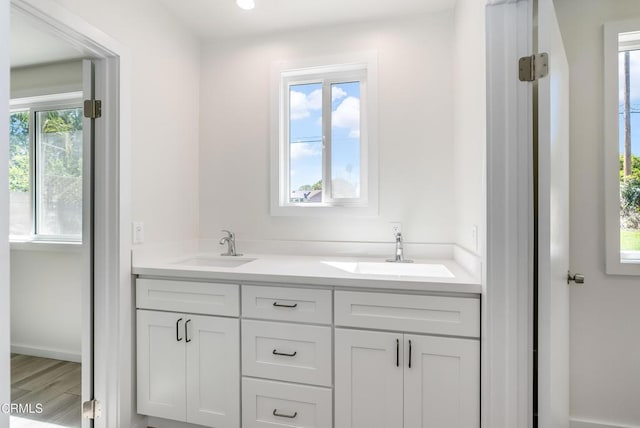8751 Odessa Ave, North Hills, CA 91343 - bathroom featuring double vanity, recessed lighting, and wood finished floors