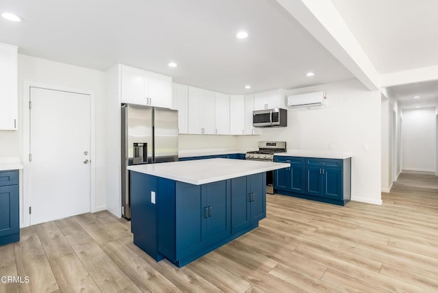 8751 Odessa Ave, North Hills, CA 91343 - kitchen with appliances with stainless steel finishes, blue cabinets, a wall mounted air conditioner, light wood-style floors, and recessed lighting
