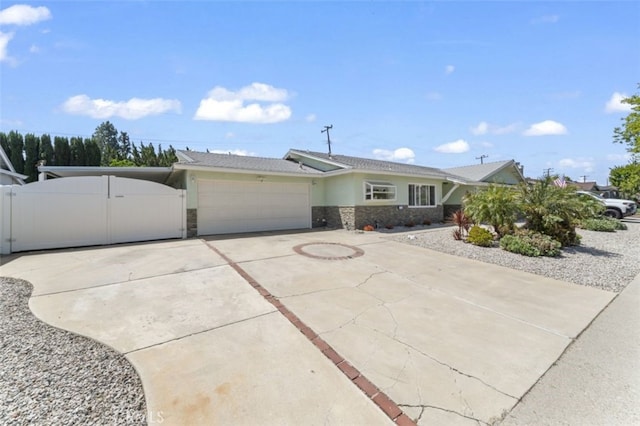 single story home featuring a gate, driveway, stone siding, a garage, and stucco siding