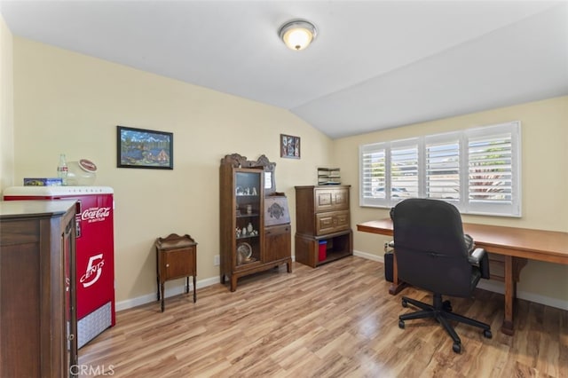 office space featuring vaulted ceiling, light wood finished floors, and baseboards